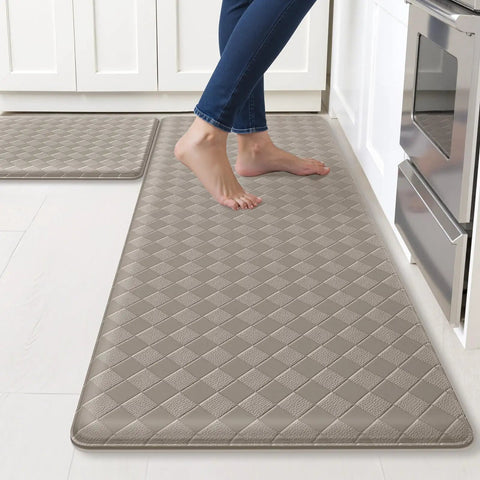 Cushioned Anti Fatigue Kitchen Mats Set 2 Pack Non Slip Floor Rugs For Standing At Sink Or Stove Waterproof Kitchen Mats For Sink And Stove 17.3x30 And 17.3x47 Inches Brown depicted with a person standing on them in a kitchen setting.