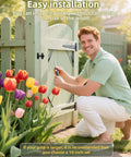 Man installing Gate Frame Kit With 8 Inch Hinges And Gate Latch For Wooden Shed And Barn Doors, surrounded by tulips