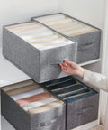 Person using Foldable Closet Organizer Bins For Clothes, Reinforced Handle, Thick Fabric Storage With Built In PP, neatly arranged.