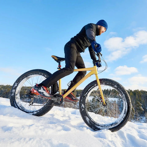 Cyclist riding in snow with Fat Tire Front Wheel Set For Snow And Beach Biking Fits 20 Or 26 Inch 4 Inch Fat Tire