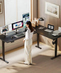 Woman working at 63 Inch Reversible L Shaped Electric Standing Desk Height Adjustable Corner Desk for Home Office, black color