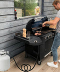 Person grilling with a gas grill connected to a Universal QCC1 Low Pressure Propane Regulator With 12 Foot Hose For Most LP Gas Grills.