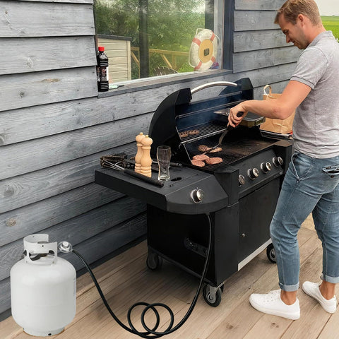 Person grilling with a gas grill connected to a Universal QCC1 Low Pressure Propane Regulator With 12 Foot Hose For Most LP Gas Grills.