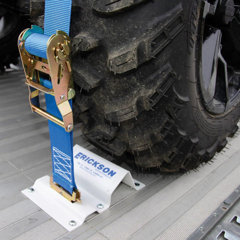Built Tough To Keep Your Rig Locked Down With Heavy Duty E Track Wheel Chock Tie Down Kit Featuring Two 2 X 6 5 Foot Ratchet Straps And Four Powder Coated Chocks For Safely Hauling ATVs Or Mowers, showing tire secured with blue ratchet strap.