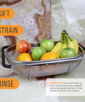 6-Quart Over The Sink Stainless Steel Colander With Expandable Rubber Handles filled with assorted fruits on a marble surface