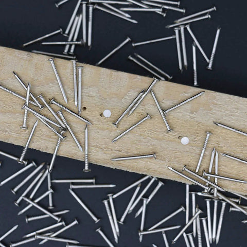 900 Pack Three Quarter Inch Nickel Plated Flat Finish Nails With Rust Proof Coating placed on wood for DIY projects.
