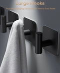 Matte black 4 Pack Heavy Duty Wall Hooks Set With 26lb Max Load, self adhesive, mounted on wall holding a towel.
