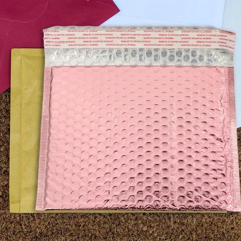 Pink bubble mailers and an open red envelope. 25 Pack Self Seal Bubble Mailer Envelopes 25x20cm Padded Cushion Mailing Bags For Shipping Cosmetics Jewelry Bulbs