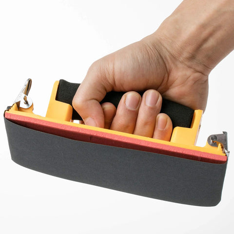 Hand holding sanding block with sheet from 18 Piece Wet Dry Sandpaper Kit 120 To 3000 Grit For Metal Wood Automotive And Furniture