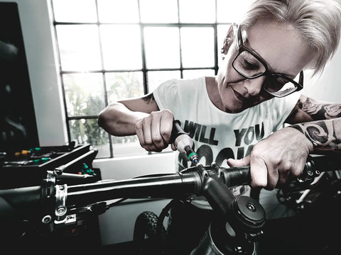 Person using Kraftform Torque Screwdriver Set With Rapidaptor Bitholder, 0.3-6.0 Nm, 27 Pieces on bicycle handlebars indoors.