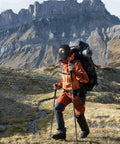 Person hiking in mountains wearing Cooling Balaclava Face Mask With Merino Wool And Lyocell, using trekking poles.
