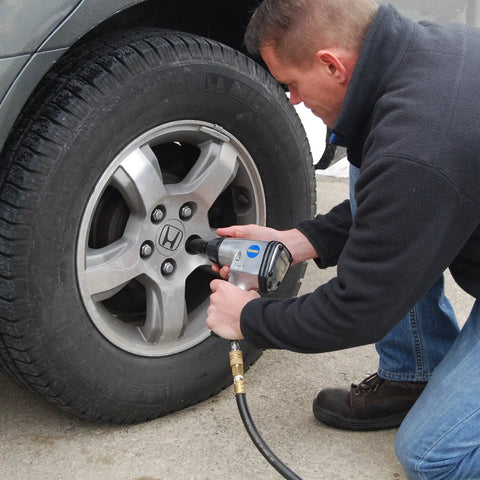 Person using ATK1002 50 Piece Ultimate Air Tool Kit With Bonus Inflation Tool for tire maintenance on a car.