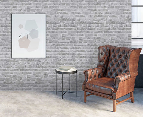 Living room with grey faux brick peel and stick wallpaper roll 17.7 by 472 inches, leather chair and abstract art on wall