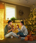 Tall Dimmable Floor Lamp With White Fabric Shade 64 Inch Standing Light Two 12W LED Bulbs 3 Brightness Levels Cozy Vibe 2700K Ambient Glow Modern Home Decor For Living Room Bedroom Kids Room next to Christmas tree and couple.