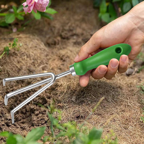 Three Tine Claw Garden Rake with ergonomic handle and stainless steel build, a handy bow rake cultivator in use for soil preparation