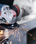 Close-up of Badass Torque 120 Volt 10 Amp X Lock Mount 4 1/2 Inch Corded Angle Grinder cutting steel with sparks flying.