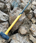 10 Pound Sledge Hammer for Heavy Duty Demolition with 35 Inch Fiberglass Handle resting on rocks