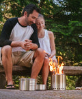 Father and daughter using Campfire 2 Pot Wood Burning Camping Stove Set For 4 Plus People Outdoor Kitchen Kit For Backpacking, Camping, And Survival With No Batteries Or Liquid Fuel Needed in forest.