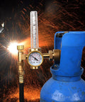 Front view of brass welding gas regulator with flow meter and gauge attached to a blue argon/CO2 cylinder.