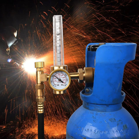 Front view of brass welding gas regulator with flow meter and gauge attached to a blue argon/CO2 cylinder.