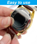 Watch with brown leather strap and gold-tone case; close-up of spring bar pin being removed from the strap.