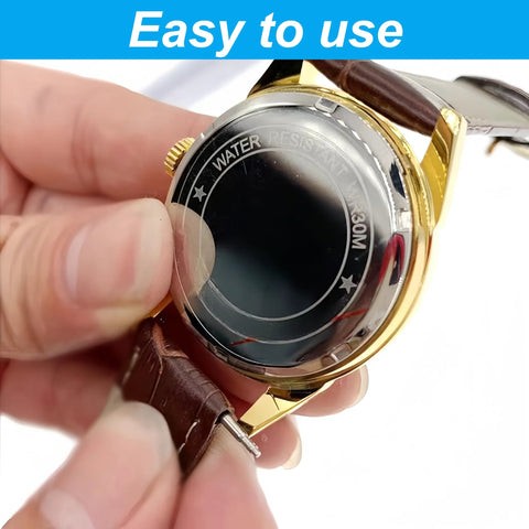 Watch with brown leather strap and gold-tone case; close-up of spring bar pin being removed from the strap.