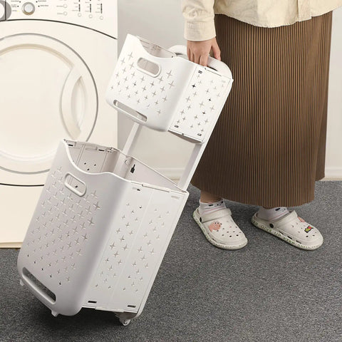 Person using collapsible wall hanging laundry baskets space saver duo set with hidden pull rod by washing machine.
