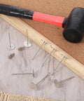Heavy Duty Upholstery Tacks 20 Piece Pack Silver Flat Head Furniture Nails arranged with a hammer on a corkboard.