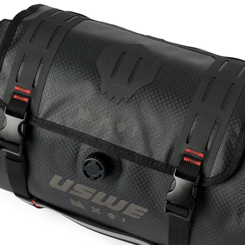 Close-up of waterproof bike handlebar bag rolltop 9L front frame storage with secure elastic straps and logo detail