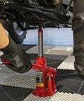 Torin BIG RED bottle jack, 2-ton capacity, under a vehicle with red hydraulic jack and chrome piston