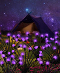 Purple Firefly Solar Lights Outdoor 2 Pack With 16 LEDs Waterproof Starburst Swaying Garden Path Lights illuminating a garden at night