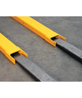 Heavy Duty Pin Lock Forklift Extensions Boss Level Steel Bars 4000 Lb Capacity No Sweat Mounting, Yellow rig attachment on floor.