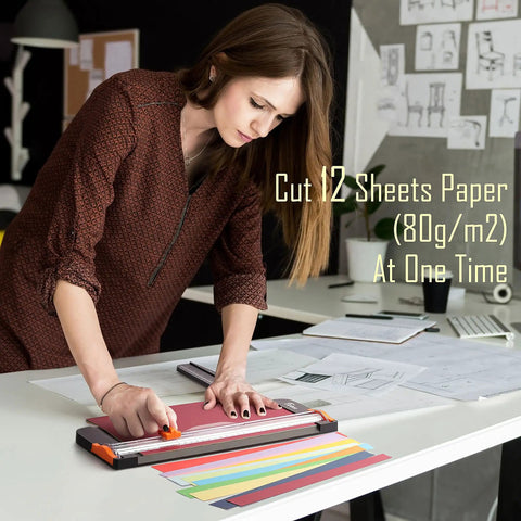 Person using 12 Inch Titanium A4 Paper Cutter With Automatic Safety Guard And Side Ruler on colorful papers, black trimmer.