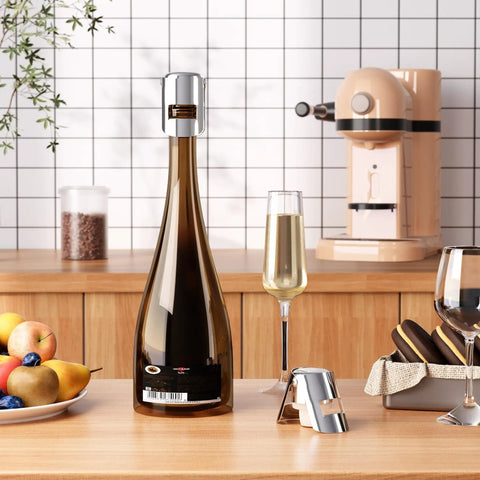 Leak Proof Champagne Stoppers With Stainless Steel Saver And Food Grade Silicone Keep Sparkling Wine Fresh Up To 7 Days Fits Champagne Cava Prosecco And Sparkling Wines Silver 2 Pack shown on a kitchen counter sealing a champagne bottle.