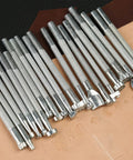 Leather Craft Tools Kit With 20 Leather Stamping Tools and hammer on tan leather surface for DIY leatherwork.