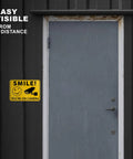 Smile Youre On Camera Signs 10x7 Outdoor Aluminum Notice Signs Single Sided Two Pack on dark exterior door, easy visible from a distance