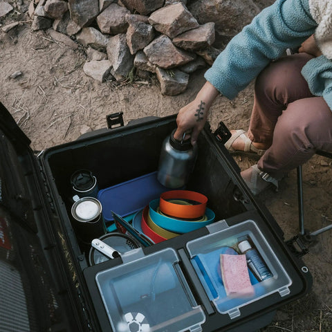 Open Trail 80 Waterproof Storage Box With Wheels, 79L outdoor gear case showing organized camping supplies inside in bright orange.