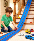 Child playing on stairs with Portable 15 Foot Flexible Race Car Track Set For Kids With One Sixty Four Scale Rebound Cars Rolls Up Track