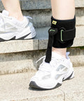 Adjustable Drop Foot AFO Brace for Unisex Use, Right Or Left Foot Ortho, Black ankle support shown on person wearing white sneakers.