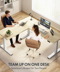 Massive 63x47 Inch L-Shaped Electric Standing Desk In Warm Maple Finish with two users working.