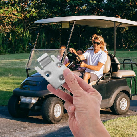 Hand holding Metal Golf Cart Seat Bottom Hinge And Plate Replacement in front of a golf cart on a sunny day.