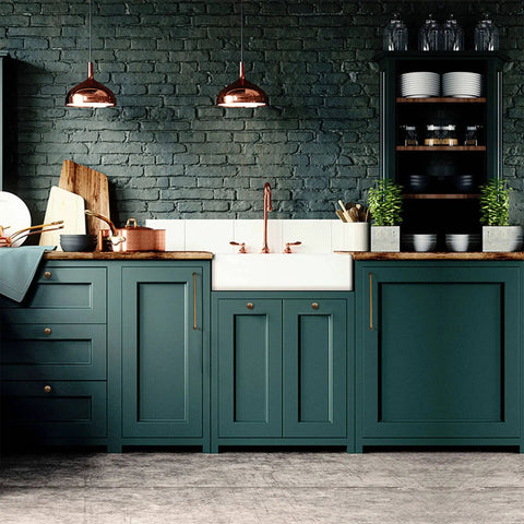 Modern kitchen with green cabinets and copper accents, featuring farmhouse sink and wooden countertop, under copper pendant lights.