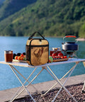 Desert Camel Train Insulated Lunch Bag For Women And Men Portable Cooler Tote with fruits and tea on a picnic table by the lake.