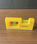 QERDIVO Spirit Levels Mini Horizontal Vertical Pockets Spirit Levels Spirit Bubble Leveler on wooden surface, showing yellow compact design.