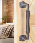 10 Inch Heavy Duty Rustic Sliding Barn Door Pull Handle In Oil Rubbed Bronze Finish installed on wooden door indoors.