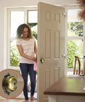 Woman entering home with Vintage Victorian Twist Bell With Key Plate Mechanical Doorbell visible on open door