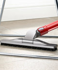 Articulating Hard Floor Tool with Swivel Brush Head cleaning under chair on a tiled floor