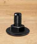 Front view of black stainless steel bolt with flat washer on wood surface