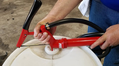 Person using Lincoln 1335 Lever Action Fluid Transfer Pump For 16 To 55 Gallon Drums With 8.5 Fluid Ounces Per Stroke, 2 Inch Bung