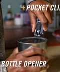 Blue Gerber Prybrid multi-tool with pocket clip being used to pry open a metal can; bottle opener included